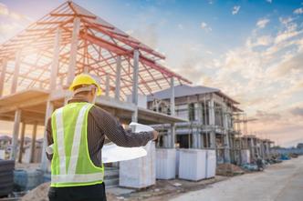 Construction worker with blueprints on job site